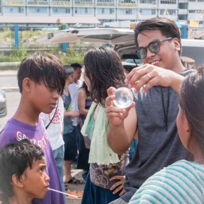 スラム街でアルビンがコンタクトジャグリング披露 セブ島のスラム街でGocooの太鼓ワークショップ