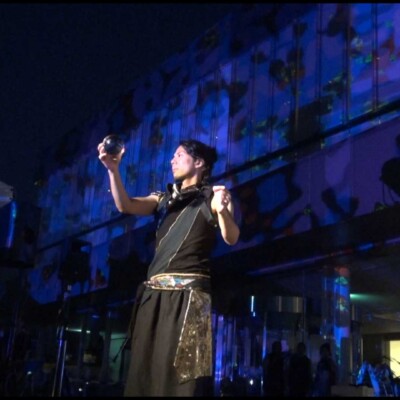 おこたんぺのコンタクトジャグリング しいのき迎賓館のミュージアムウィークで、デジタル掛け軸の前でライトパフォーマンス