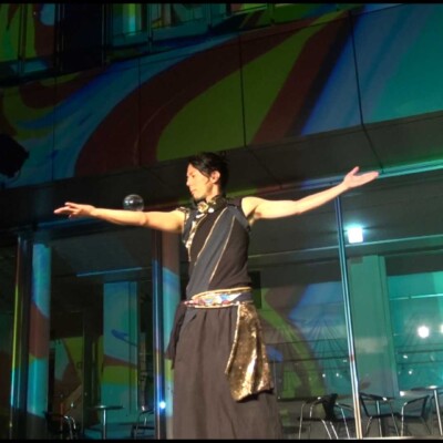 おこたんぺのコンタクトジャグリング しいのき迎賓館のミュージアムウィークで、デジタル掛け軸の前でライトパフォーマンス