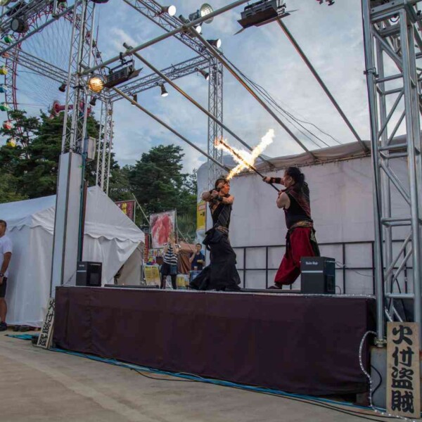 ナイトプールのビーチで炎剣バトル 西武園ゆうえんちのプールの夏イベントを盛り上げるファイアーパフォーマンス
