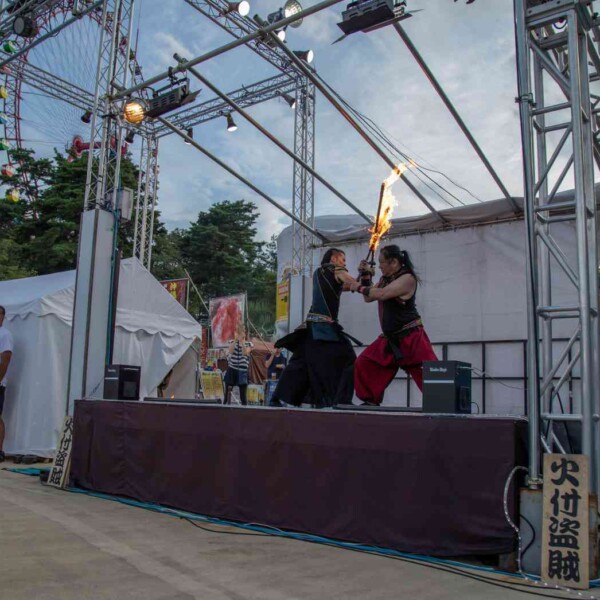 ナイトプールのビーチで炎剣バトル 西武園ゆうえんちのプールの夏イベントを盛り上げるファイアーパフォーマンス